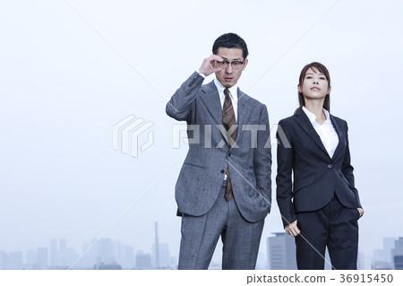 站立在屋頂的商人和女實業家 站立在屋頂的商人和女實業家 36915450