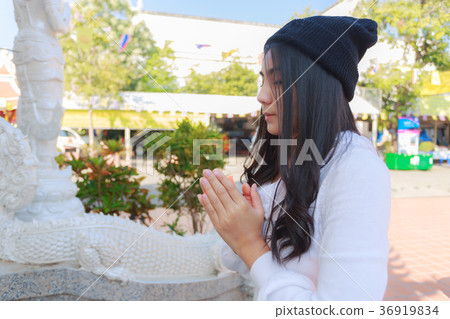 Asian woman pay homage to a Buddha image Asian woman pay homage to a Buddha image 36919834
