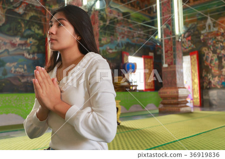 Asian woman pay homage to a Buddha image 36919836