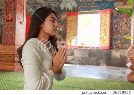 Asian woman pay homage to a Buddha image 36919837