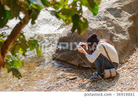 Woman hiking around mountains near the river Woman hiking around mountains near the river 36919881