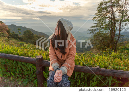 Asian woman relaxing on top of a mountain Asian woman relaxing on top of a mountain 36920123