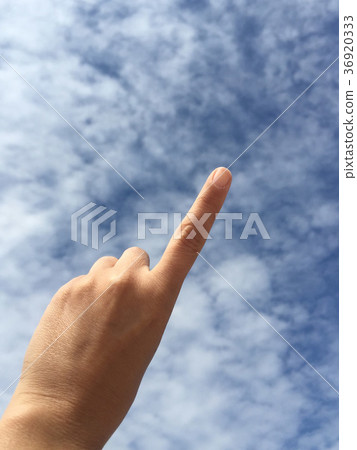 female hand pointing to something on blue sky female hand pointing to something on blue sky 36920333