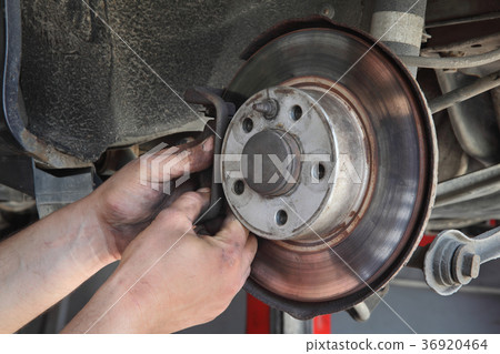 Car mechanic working on disc brakes Car mechanic working on disc brakes 36920464