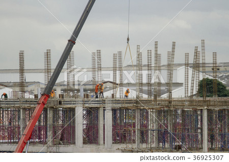 Red lift cranes with workers under construction. Red lift cranes with workers under construction. 36925307