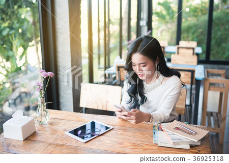 Asia girl using mobile phone at the cafe Asia girl using mobile phone at the cafe 36925318