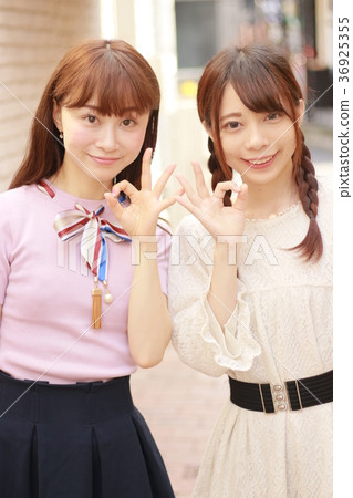 Two young women in the city sign OK 36925355