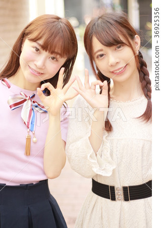 兩個年輕女子在城市簽署確定 兩個年輕女子在城市簽署確定 36925356