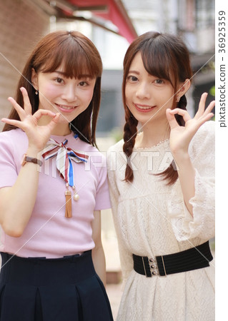 兩個年輕女子在城市簽署確定 兩個年輕女子在城市簽署確定 36925359
