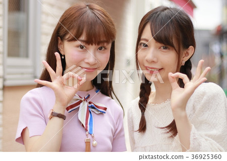 兩個年輕女子在城市簽署確定 兩個年輕女子在城市簽署確定 36925360