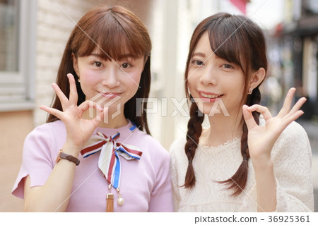 兩個年輕女子在城市簽署確定 兩個年輕女子在城市簽署確定 36925361