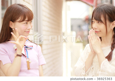 Two young women in the city sign OK 36925363