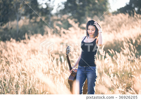 Beautiful young girl carrying her guitar 36926205
