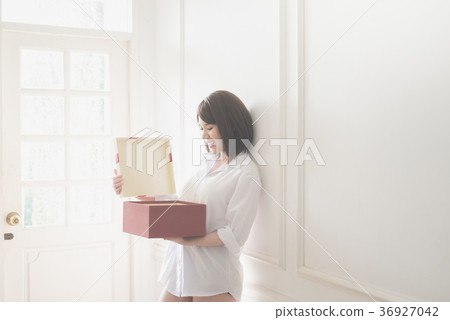 Asian girl open red gift box under sun light from a window 36927042