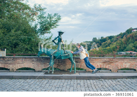 Girl in a white vest with a backpack. Next bronze 36931061