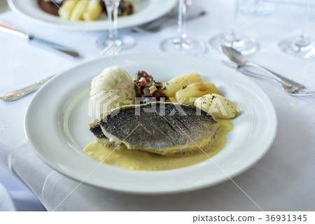 White dinner plate with fish filet steak and 36931345