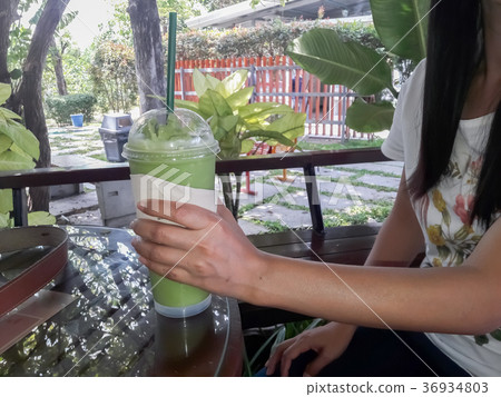 Green tea blended in female hands. Green tea blended in female hands. 36934803