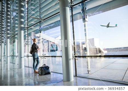 Young woman waiting at airport, looking through 36934857