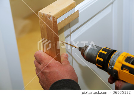 Assembling furniture and drills the cabinet door 36935152