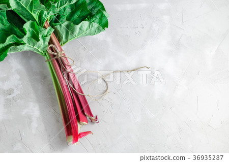 Fresh organic rhubarb on grey concrete background Fresh organic rhubarb on grey concrete background 36935287