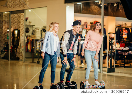 man and two woman riding on Hoverboard in mall 36936947