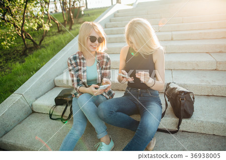Two beautiful students watching media content on Two beautiful students watching media content on 36938005