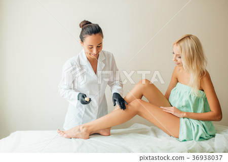 Beautician waxing woman a leg at salon. Depilation 36938037