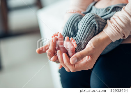 Baby's foot in mother hands 36938464