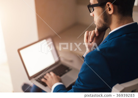 Young businessman working with laptop at office Young businessman working with laptop at office 36939283