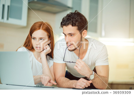 Couple Using Laptop On Desk At Home and think 36939309