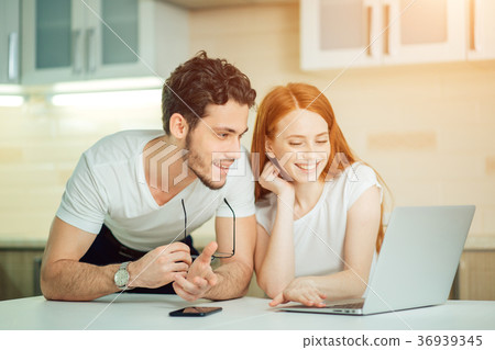 couple watching photoes from honey moon together couple watching photoes from honey moon together 36939345
