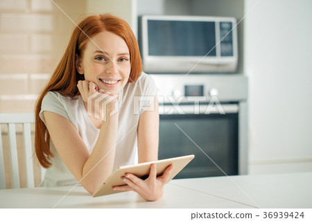 happy young woman holding tablet and looking at happy young woman holding tablet and looking at 36939424