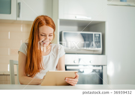 Happy woman working using digital tablet on desk 36939432