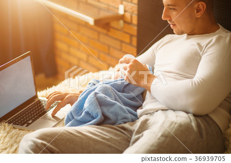 man feeding little baby while lying on bed and man feeding little baby while lying on bed and 36939705