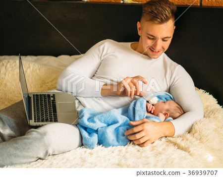 man feeding little baby while lying on bed and 36939707