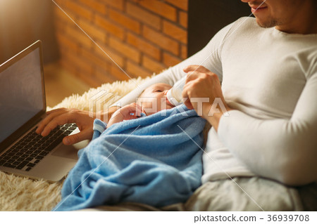 man feeding little baby while lying on bed and 36939708