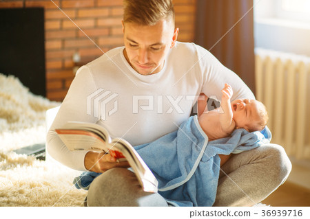 Young father and reading book to little baby 36939716