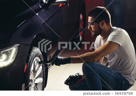 man checks polishing with a torch 36939799