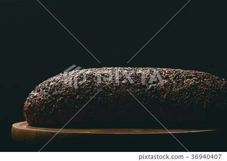 Black bread with seeds on dark background Black bread with seeds on dark background 36940407