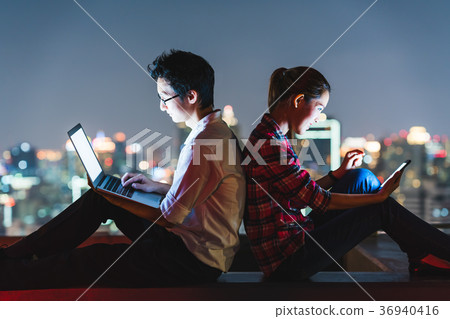 Asian couple using laptop and smartphone at night 36940416