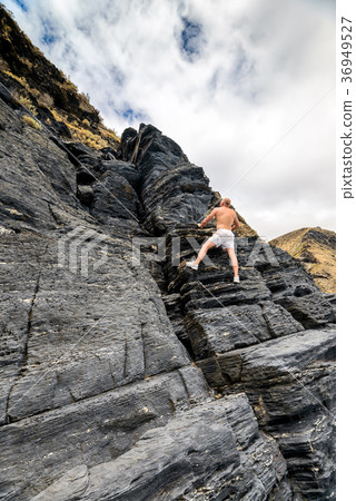 Man climbing up the rock 36949527