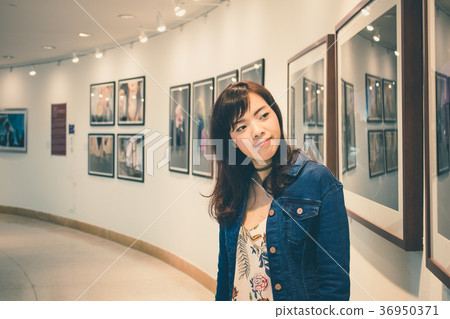 Young Asian woman walking around in the museum. Young Asian woman walking around in the museum. 36950371
