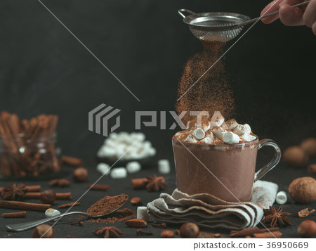cinnamon powder flying over glass mug with hot cinnamon powder flying over glass mug with hot 36950669
