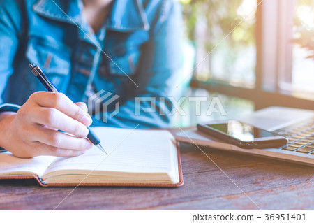 Woman hands with pen writing on notebook. Woman hands with pen writing on notebook. 36951401