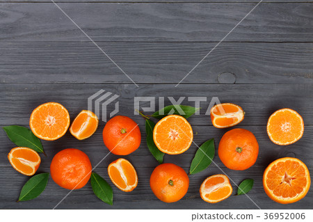 tangerine with leaves on black wooden background tangerine with leaves on black wooden background 36952006