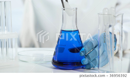 Chemistry teacher putting dry ice into blue liquid 36956392