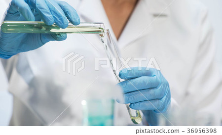 Medical worker pouring yellow liquid into test 36956398