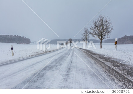 Lonely icy winter road with white snowy track 36958791