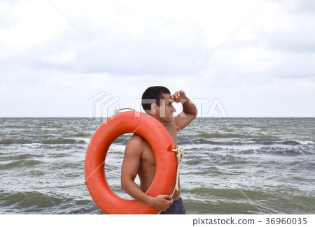The man on the beach with a lifebuoy The man on the beach with a lifebuoy 36960035