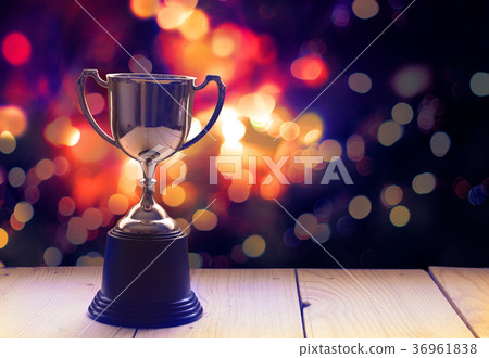Win prize trophy on wood table with abstract bokeh 36961838